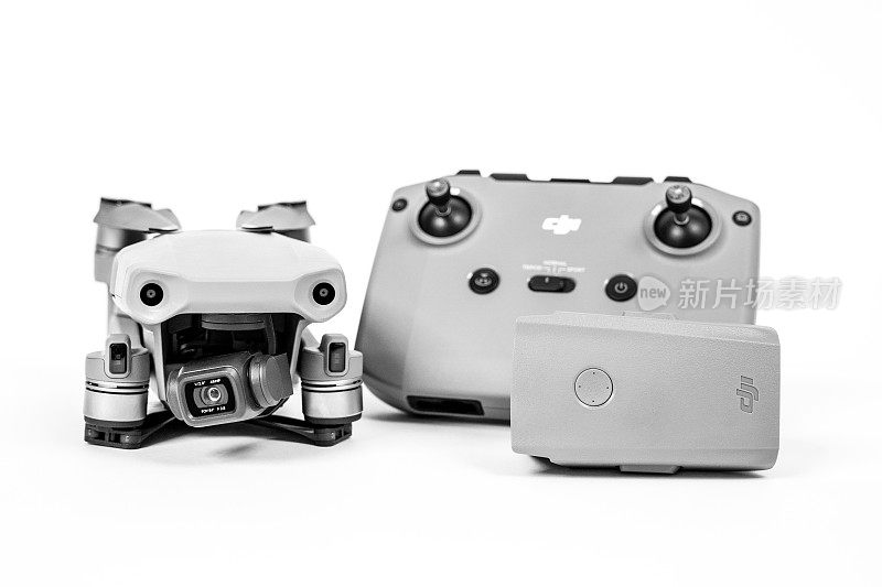 基本的无人机DJI Mavic Air 2，带有摄像头，带有操纵杆的遥控器，电池在白色背景，拷贝空间，正面视图。